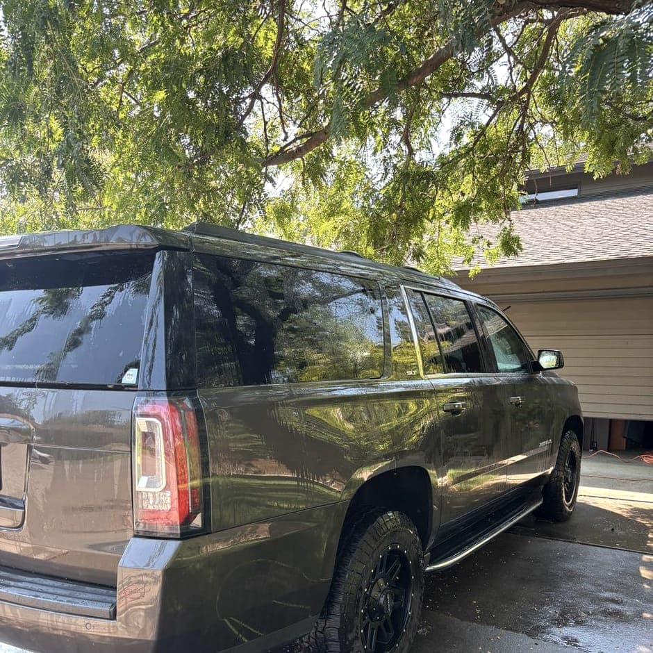 Detailer reaching into a cabin to wipe down the interior