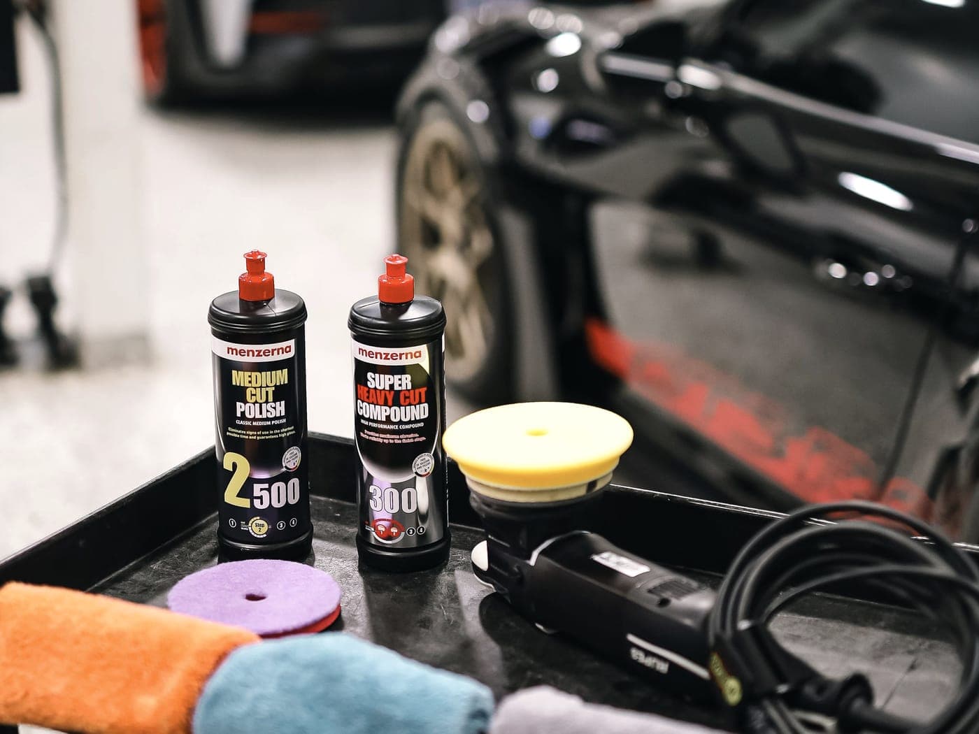 Detailing products and equipment laid out beside the vehicle