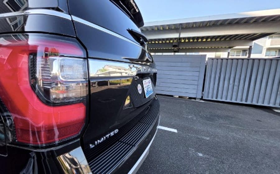 Rear taillight and badge of a black Ford Expedition after a full detail